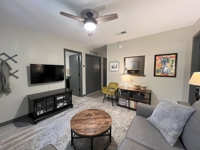 living room featuring light hardwood / wood-style flooring and ceiling fan