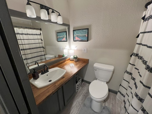 bathroom with hardwood / wood-style flooring, toilet, and vanity