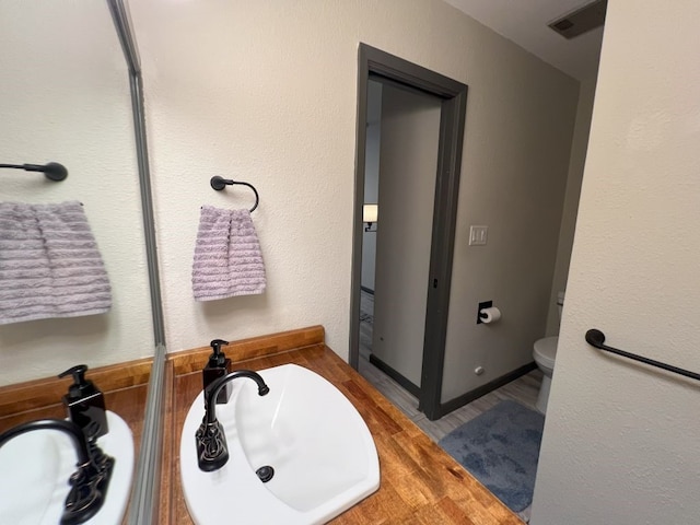 bathroom featuring sink, hardwood / wood-style flooring, and toilet