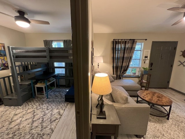 living room featuring light hardwood / wood-style flooring and ceiling fan