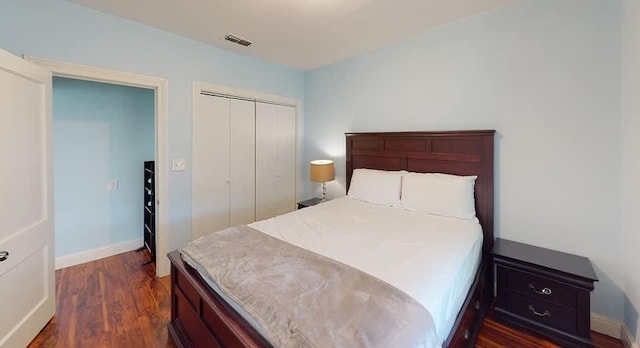 bedroom with dark hardwood / wood-style floors and a closet