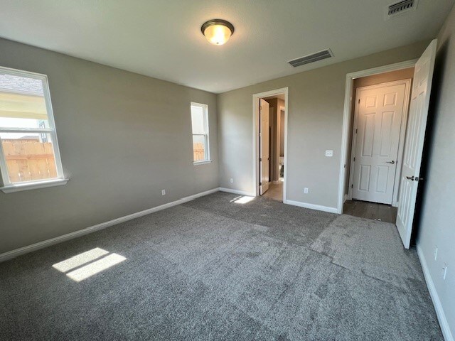 unfurnished bedroom with multiple windows and carpet flooring