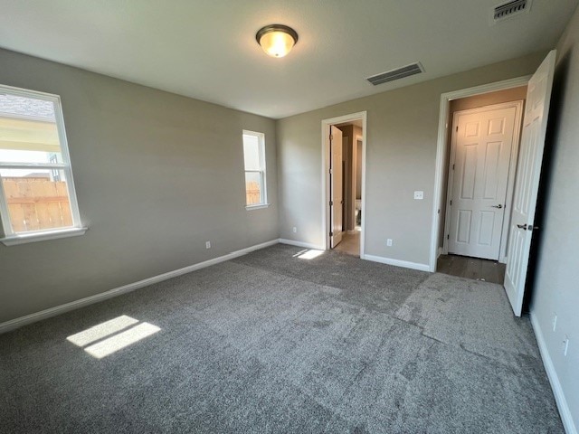 unfurnished bedroom with dark colored carpet