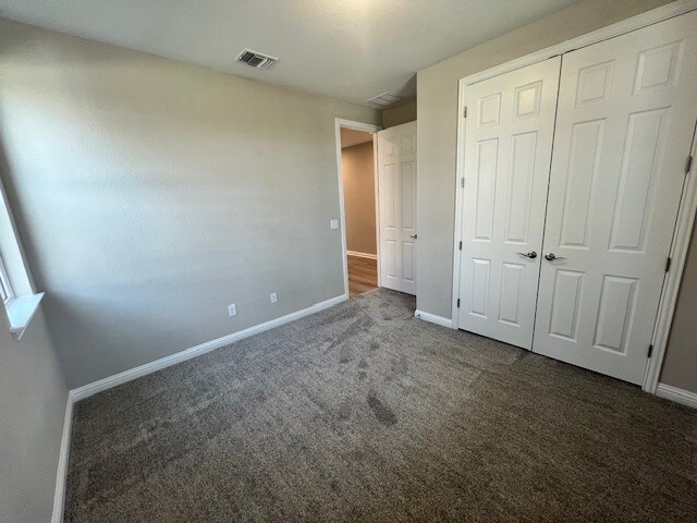 unfurnished bedroom featuring carpet and a closet