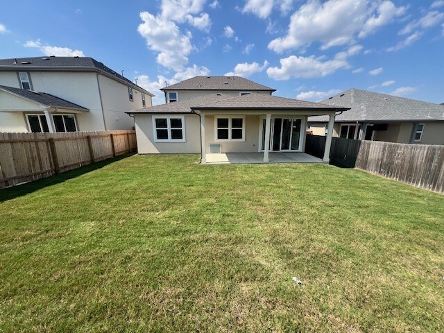 back of house featuring a patio area and a lawn