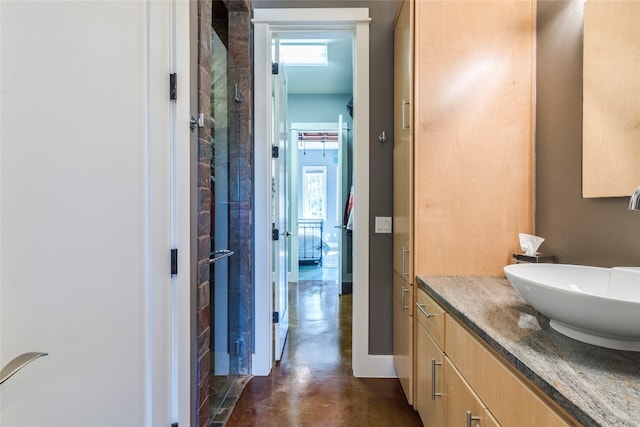 bathroom featuring concrete floors, a healthy amount of sunlight, a shower with door, and vanity