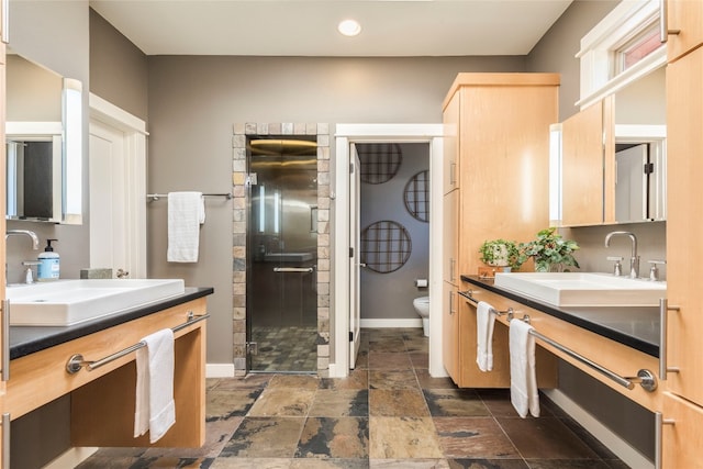 bathroom with vanity, a shower with shower door, toilet, and tile patterned floors