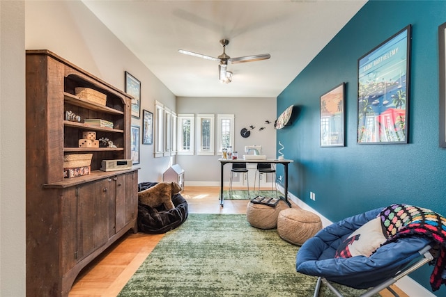 sitting room featuring light wood-type flooring and ceiling fan