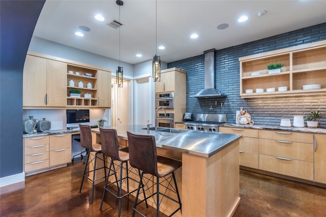 kitchen with wall chimney range hood, range, pendant lighting, a breakfast bar area, and a center island with sink