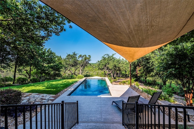 view of swimming pool featuring a patio area and a yard