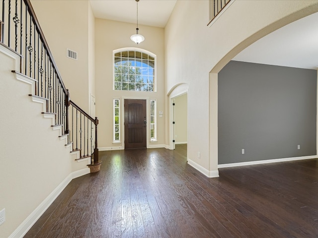 foyer entrance with wood-type flooring and a high ceiling