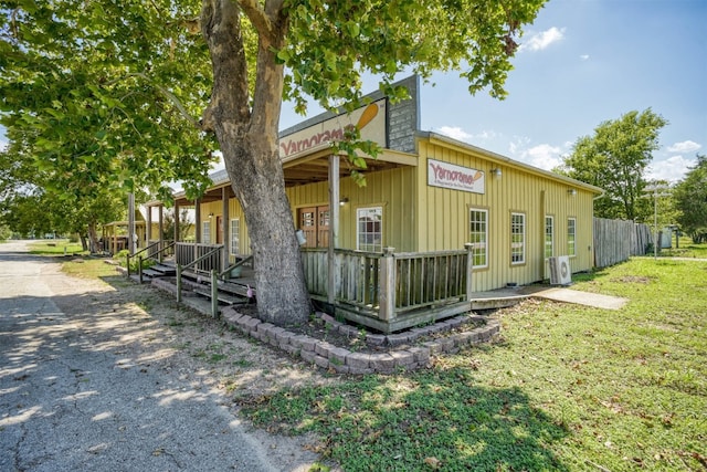 view of property exterior featuring ac unit, a lawn, and covered porch