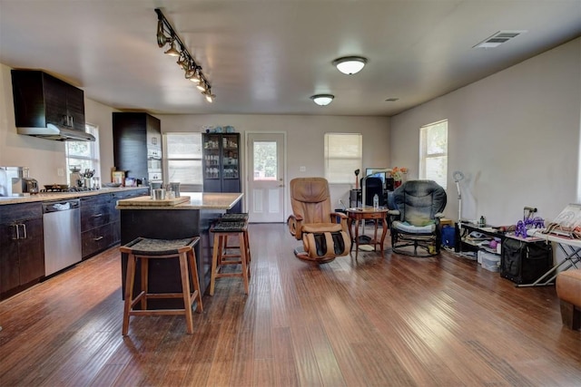 128 Gonzales St, Paige, TX 78659 - kitchen with visible vents, a kitchen bar, a kitchen island, dark wood-type flooring, and stainless steel dishwasher