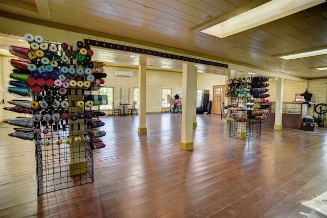 128 Gonzales St, Paige, TX 78659 - gym with a wall unit AC, wooden ceiling, a skylight, and wood-type flooring