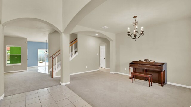 foyer with light carpet and a chandelier