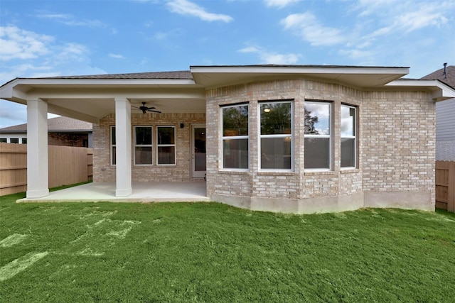 back of property with a lawn, ceiling fan, and a patio