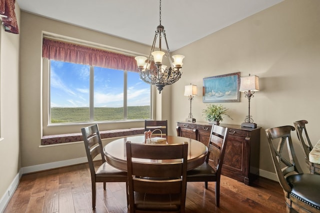 dining space with dark hardwood / wood-style flooring and a chandelier