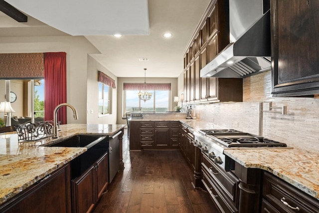 kitchen featuring wall chimney range hood, sink, dark hardwood / wood-style floors, and a healthy amount of sunlight