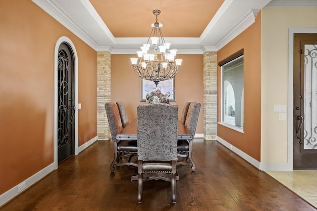 dining area featuring a notable chandelier, hardwood / wood-style floors, and a tray ceiling