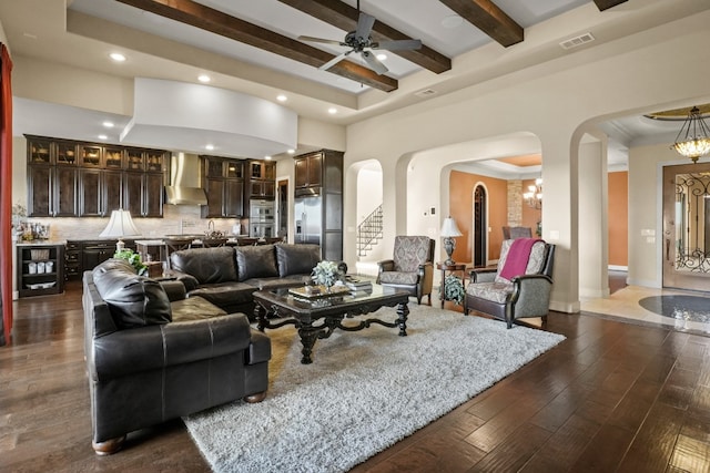 living room featuring a tray ceiling, beamed ceiling, dark wood-type flooring, and ceiling fan with notable chandelier