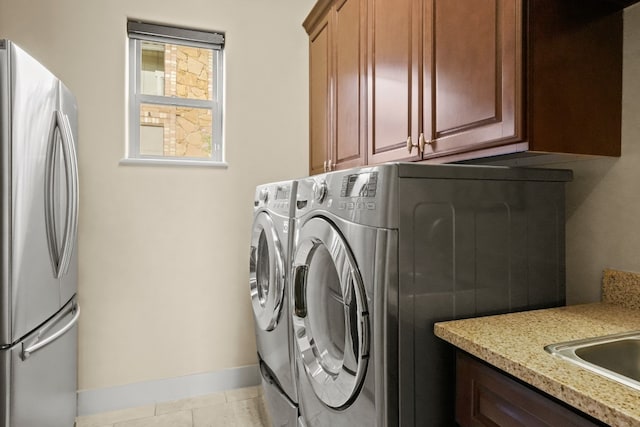 laundry room featuring sink, separate washer and dryer, cabinets, and light tile patterned floors