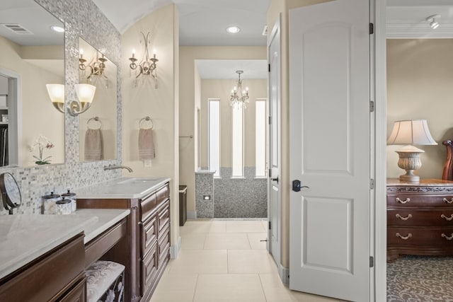 bathroom with vanity, a chandelier, tile patterned flooring, and tasteful backsplash