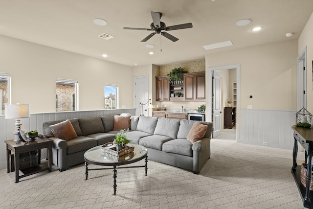 living room with ceiling fan and light colored carpet