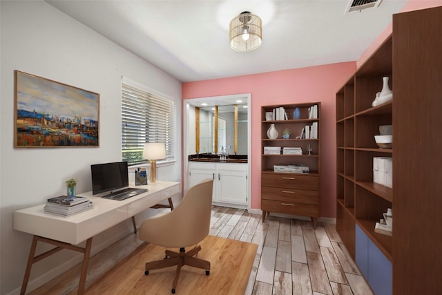 office area with sink and light hardwood / wood-style flooring