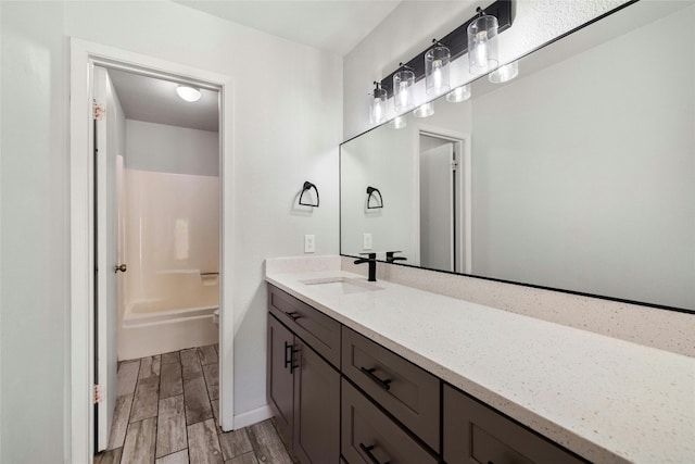 bathroom with hardwood / wood-style flooring, vanity, and a shower