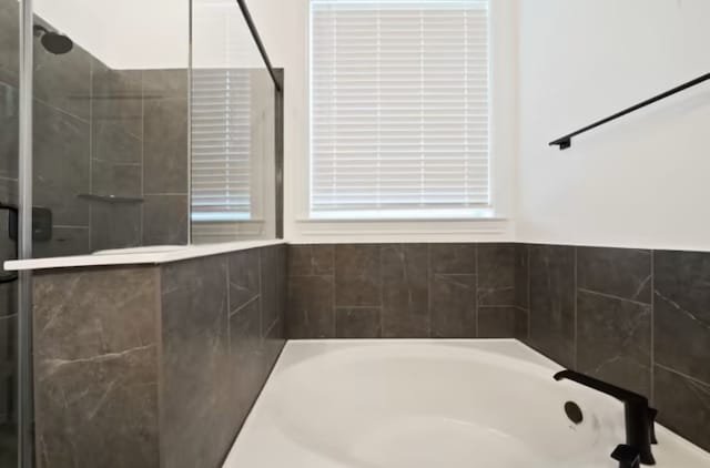 bathroom featuring tiled tub