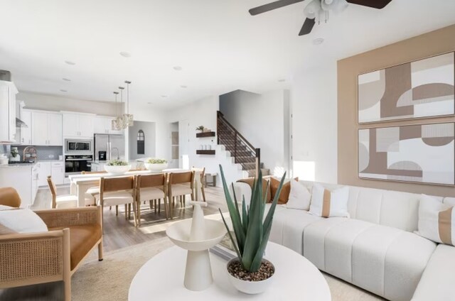 living room featuring light hardwood / wood-style floors and ceiling fan