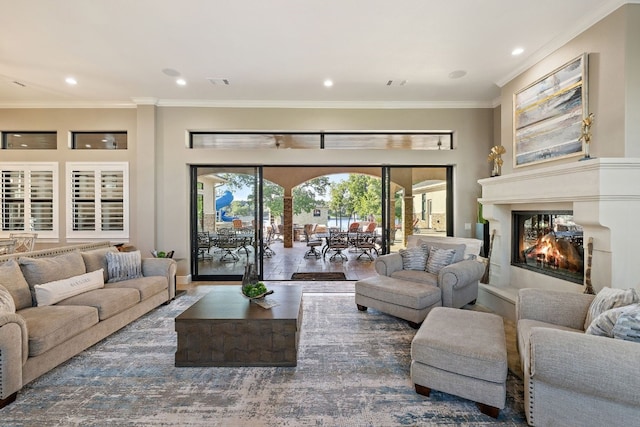 911 Legends Pkwy, Kingsland, TX 78639 - living area featuring a glass covered fireplace, ornamental molding, wood finished floors, and recessed lighting