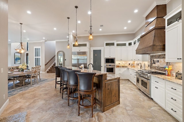 911 Legends Pkwy, Kingsland, TX 78639 - kitchen featuring built in appliances, a sink, crown molding, backsplash, and an island with sink