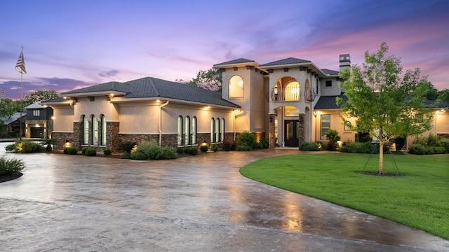 911 Legends Pkwy, Kingsland, TX 78639 - mediterranean / spanish house with curved driveway, stone siding, a lawn, and stucco siding