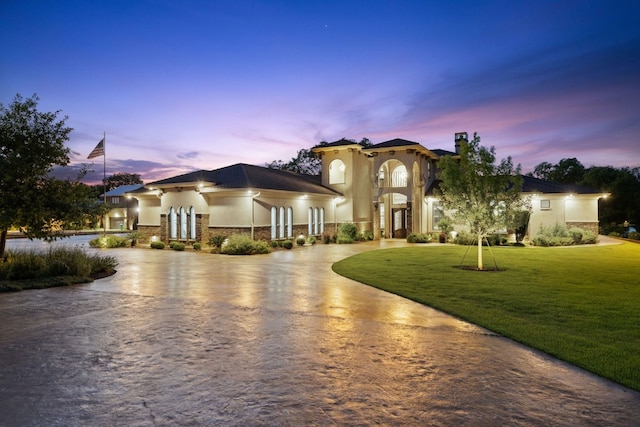 911 Legends Pkwy, Kingsland, TX 78639 - mediterranean / spanish home featuring curved driveway, stucco siding, a front lawn, and stone siding