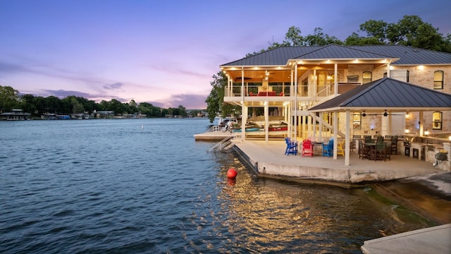 dock area featuring a balcony, a water view, and a patio area