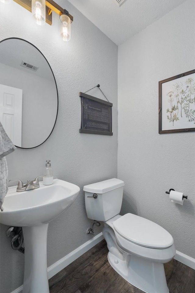 bathroom with toilet and hardwood / wood-style floors