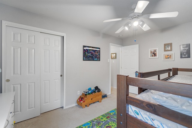 carpeted bedroom featuring ceiling fan and a closet