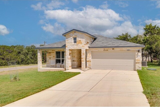 view of front of property with central air condition unit, a garage, a porch, and a front yard