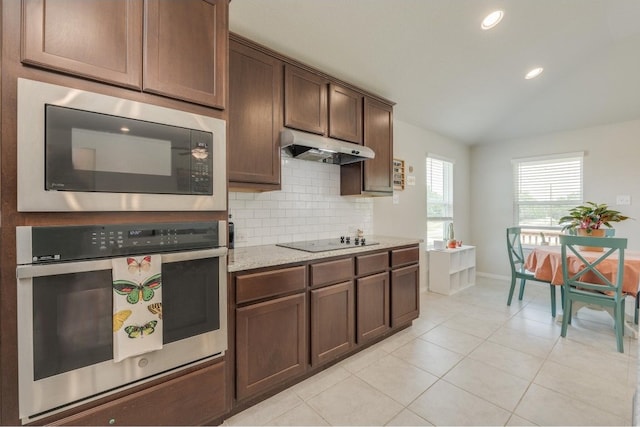 kitchen featuring stainless steel oven, black electric cooktop, dark brown cabinets, built in microwave, and backsplash