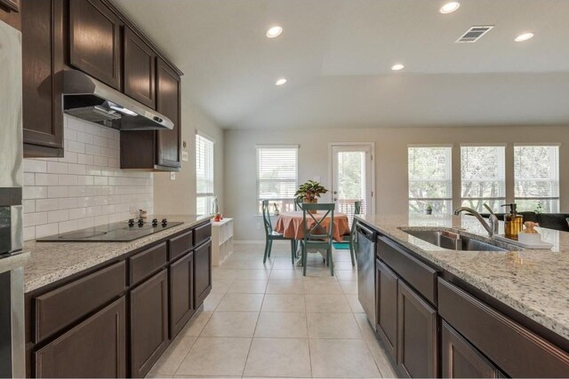 kitchen featuring sink, light tile patterned floors, decorative backsplash, lofted ceiling, and black electric cooktop