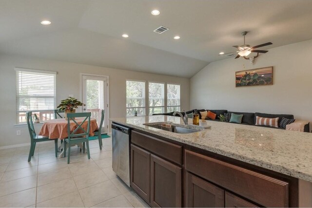 kitchen featuring light tile patterned floors, stainless steel dishwasher, light stone countertops, vaulted ceiling, and sink