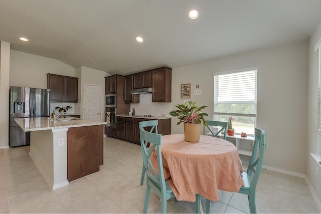 kitchen featuring a kitchen island with sink, sink, appliances with stainless steel finishes, and light tile patterned floors