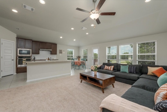 living room featuring ceiling fan, vaulted ceiling, and light tile patterned floors