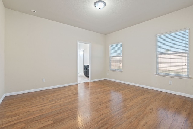 empty room featuring a healthy amount of sunlight and hardwood / wood-style floors