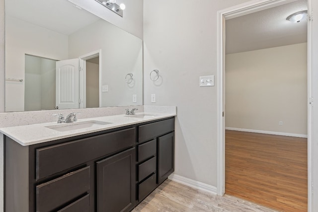 bathroom with hardwood / wood-style flooring and double vanity