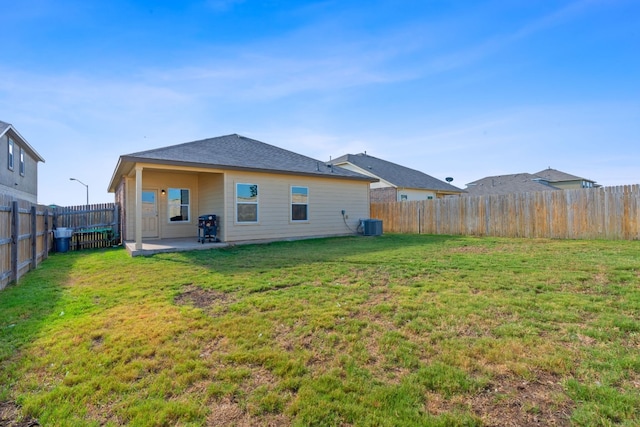 rear view of house with a patio area, central AC, and a yard