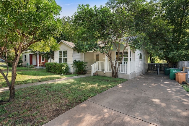 obstructed view of property featuring covered porch and a front lawn