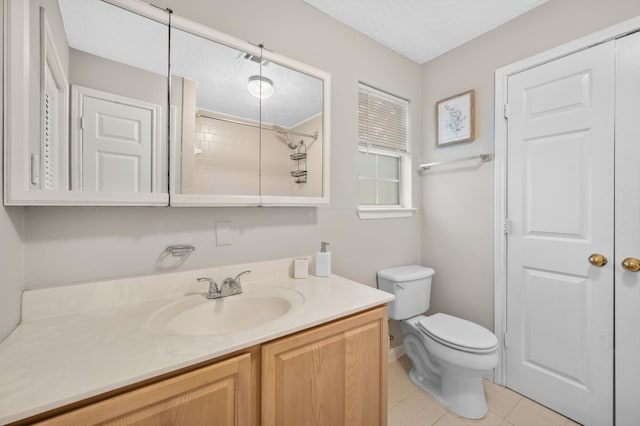 bathroom with tile patterned floors, vanity, a textured ceiling, and toilet