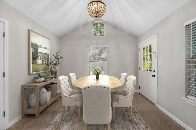 tiled dining room with a chandelier, lofted ceiling, and a healthy amount of sunlight